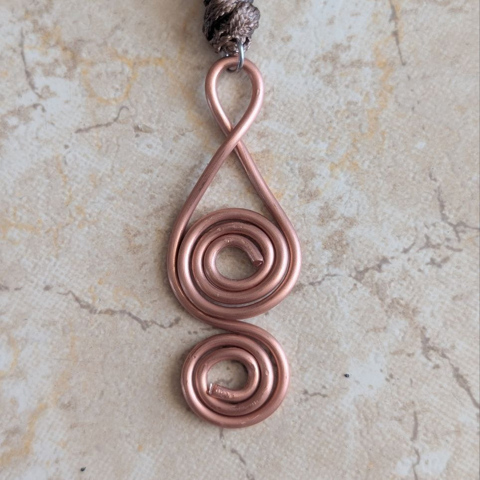 pendentif cuivre artisanal double spirale geometrie sacree