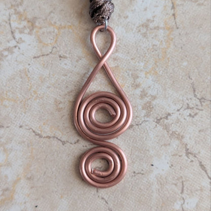 pendentif cuivre artisanal double spirale geometrie sacree